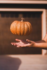 pumpkin in air above open hands 